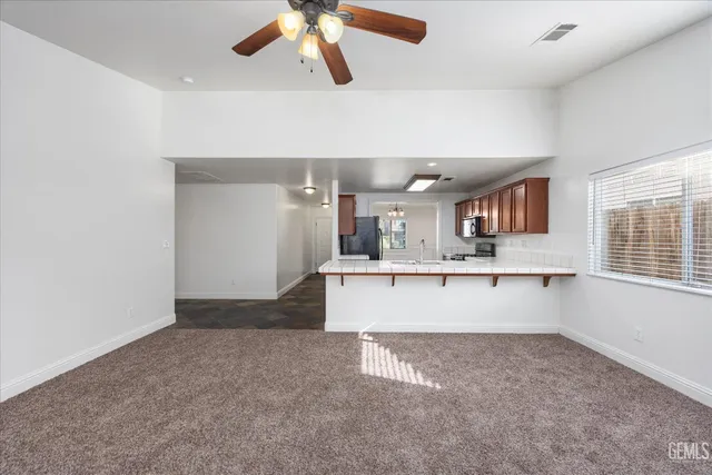 an empty room with a kitchen and a window