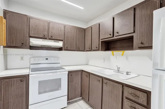 a kitchen with cabinets appliances and a sink