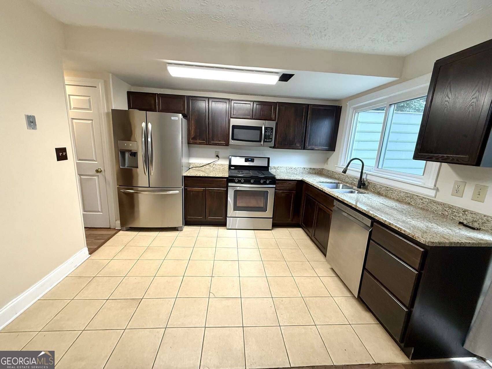 1220 Kennesaw Trace Court Kennesaw, GA 30144 - Photo 6 of 21 a kitchen with stainless steel appliances granite countertop a sink stove and refrigerator