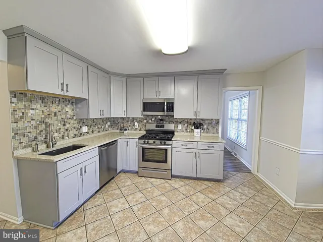 a kitchen with granite countertop cabinets stainless steel appliances and a counter space