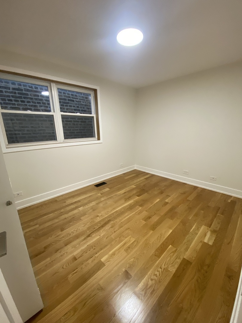 3270 North Elston Avenue, Unit 1 Chicago, IL 60618 - Photo 6 of 13 a view of an empty room with wooden floor and a window
