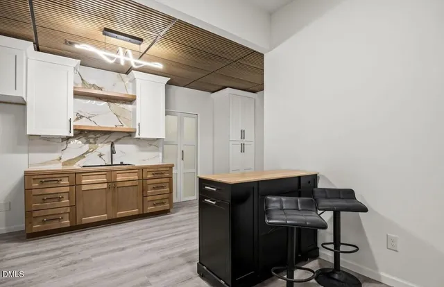 a kitchen with a sink cabinets and wooden floor