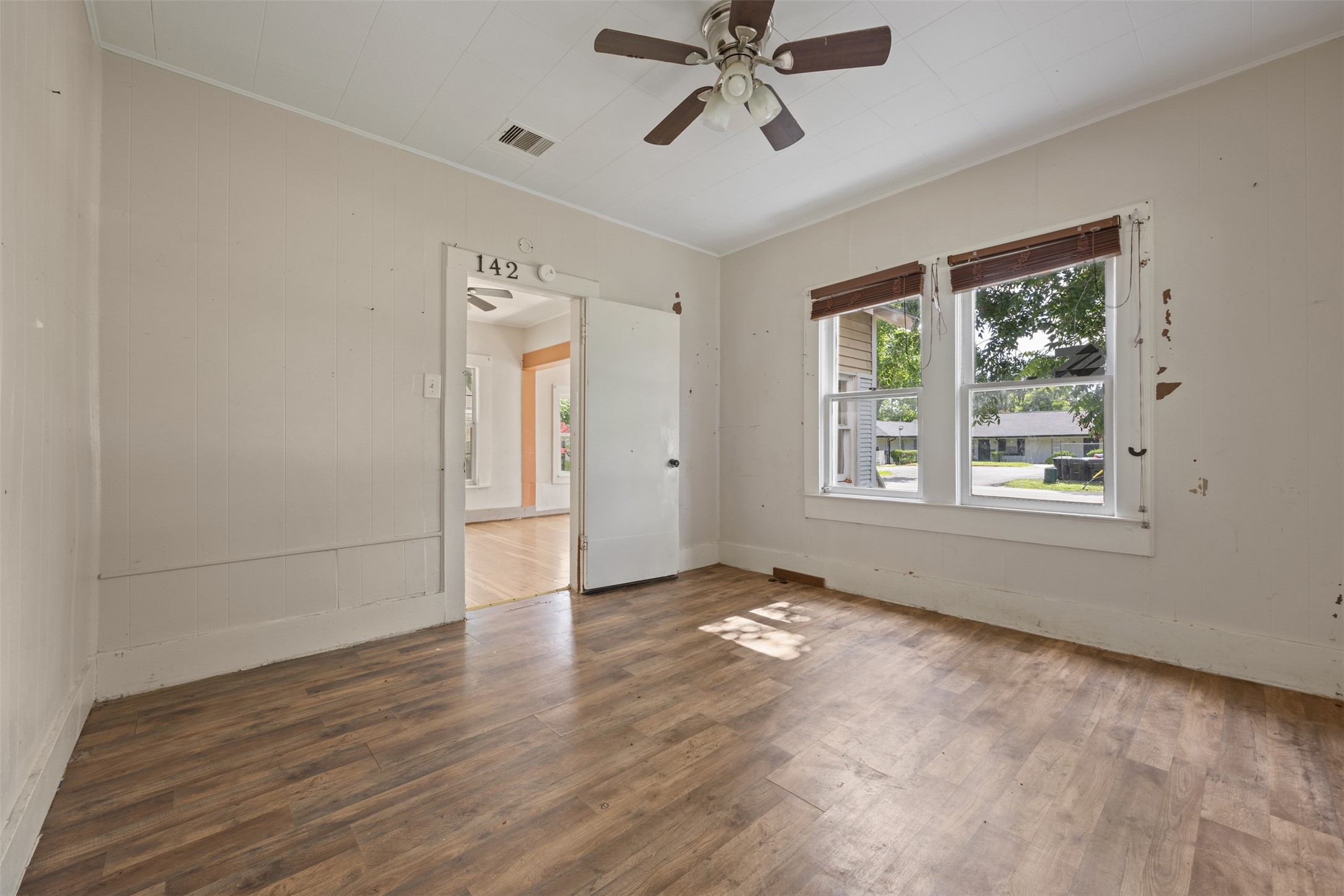 1410 8th Street Rosenberg, TX 77471 - Photo 11 of 25 a view of an empty room with a window and wooden floor