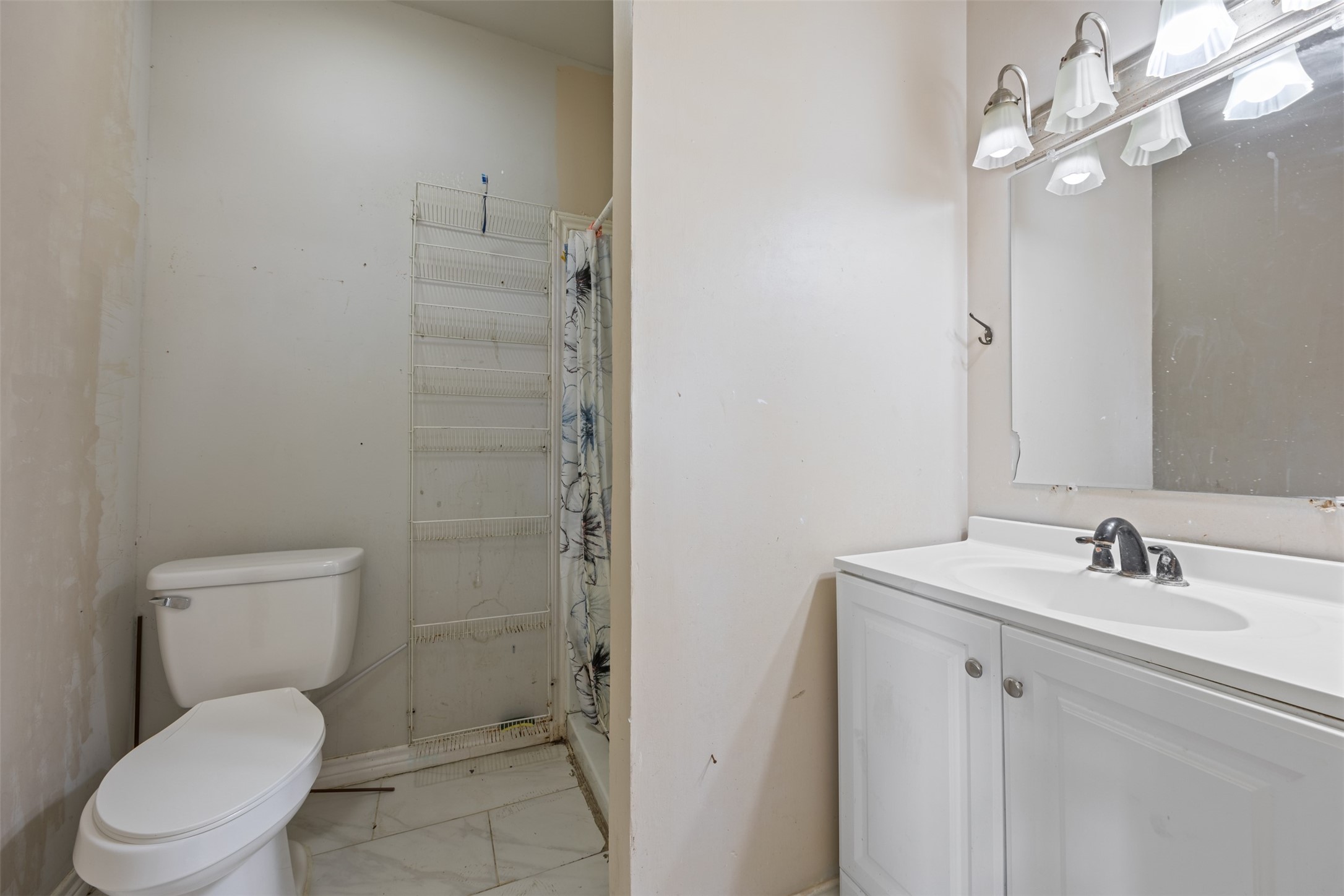 1410 8th Street Rosenberg, TX 77471 - Photo 15 of 25 a bathroom with a toilet a sink a mirror and vanity