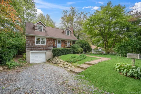 a front view of a house with a yard and trees