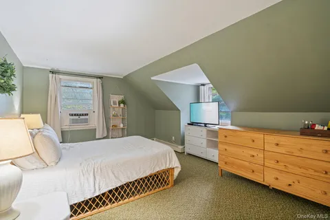 a view of a bedroom with baby crib and a window