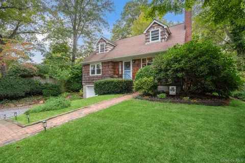 a front view of a house with yard and green space