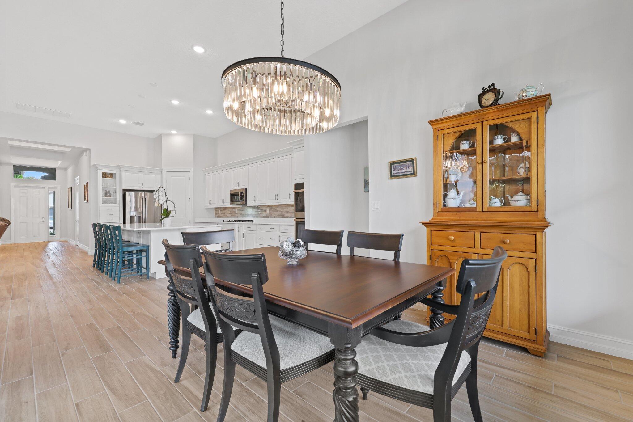 8887 Leon Circle Parkland, FL 33076 - Photo 13 of 54 a view of a dining room with furniture wooden floor and chandelier