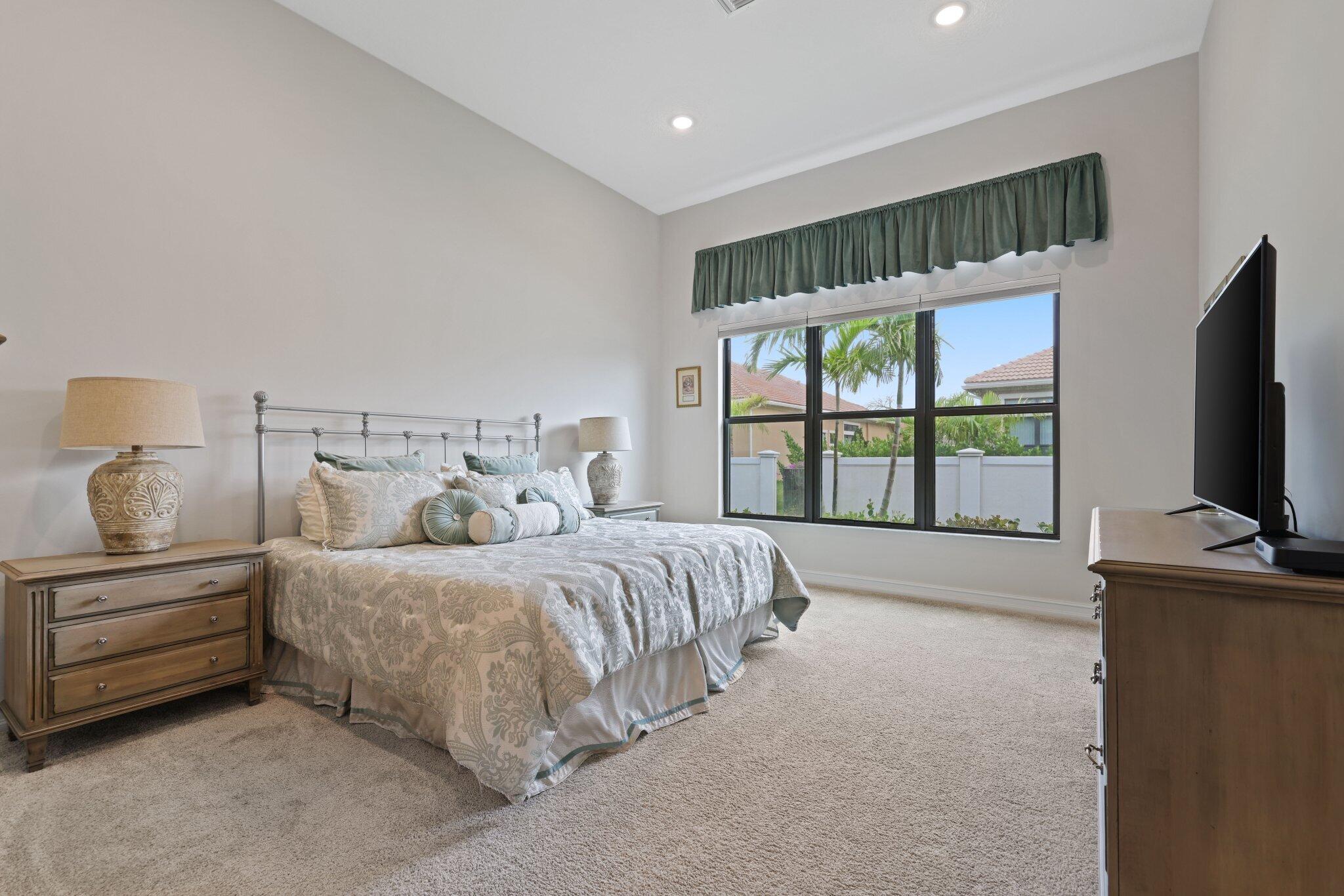 8887 Leon Circle Parkland, FL 33076 - Photo 15 of 54 a bedroom with a bed and a flat tv screen on dresser