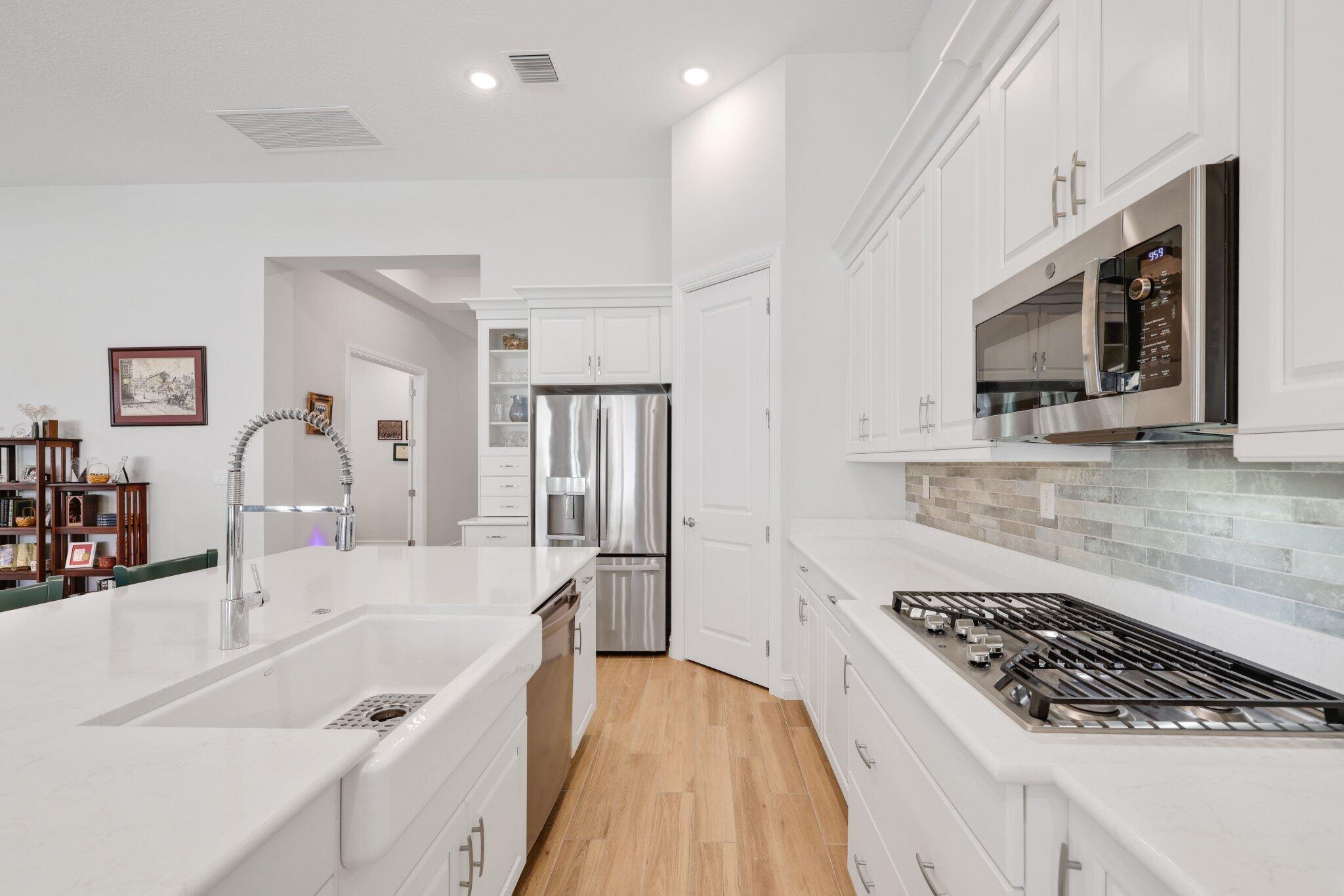 8887 Leon Circle Parkland, FL 33076 - Photo 8 of 54 a large kitchen with a sink stainless steel appliances and cabinets