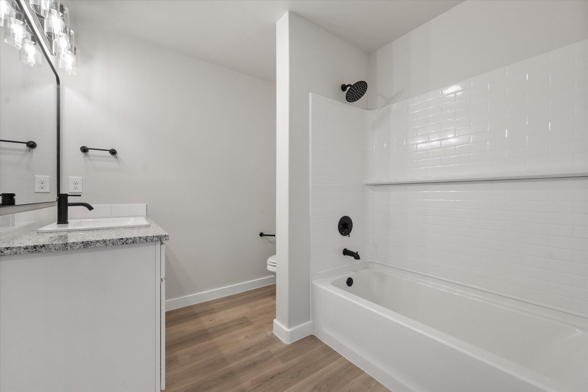 2332 136th Street Lubbock, TX 79423 - Photo 14 of 19 a bathroom with a granite countertop sink a toilet and shower