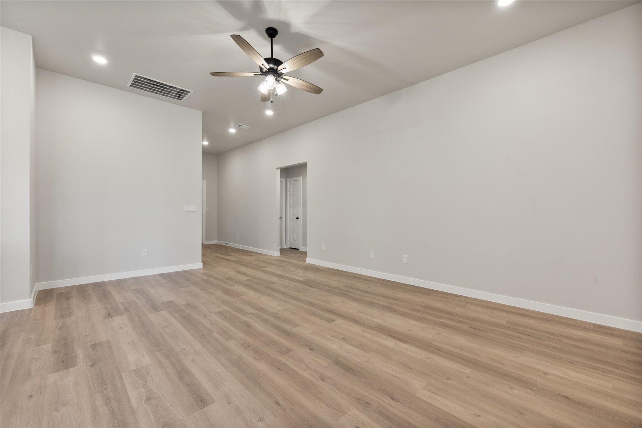 2332 136th Street Lubbock, TX 79423 - Photo 5 of 19 an empty room with wooden floor and chandelier fan