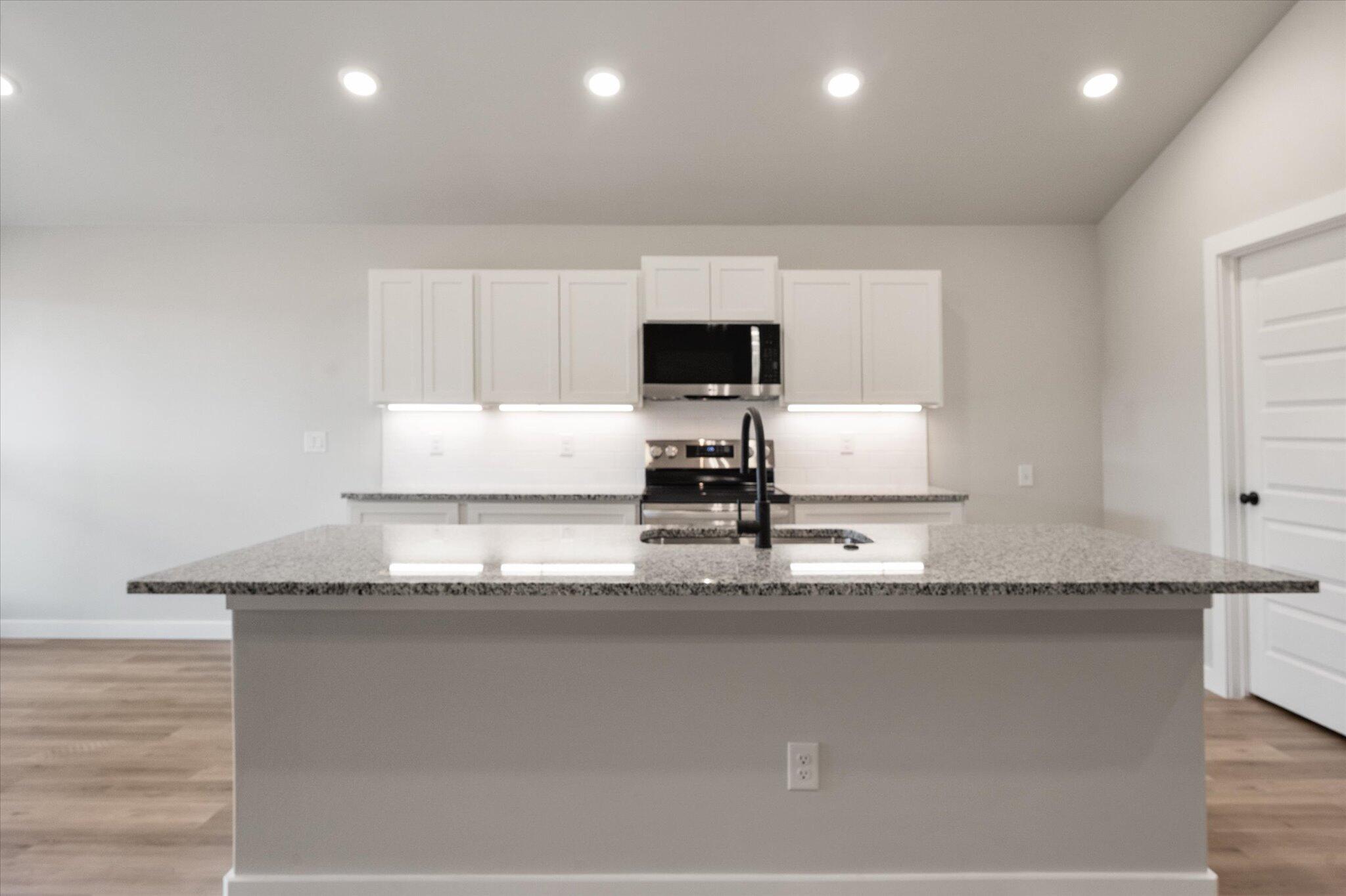 2332 136th Street Lubbock, TX 79423 - Photo 8 of 19 a kitchen with granite countertop a sink and a stove top oven