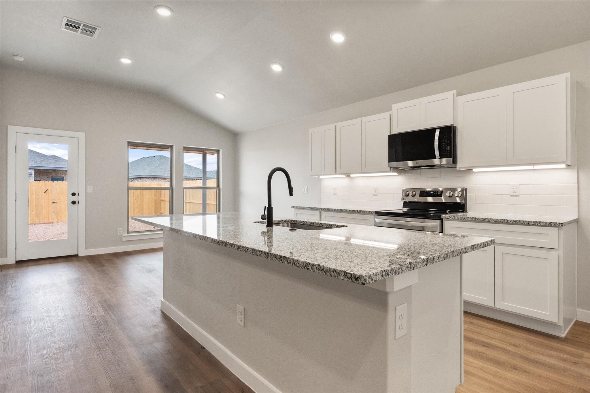 2332 136th Street Lubbock, TX 79423 - Photo 9 of 19 a kitchen with granite countertop a sink and a stove top oven