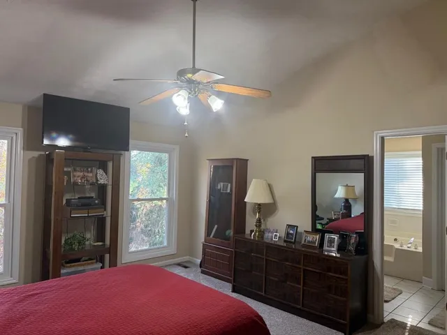 a spacious bedroom with a bed and a chandelier
