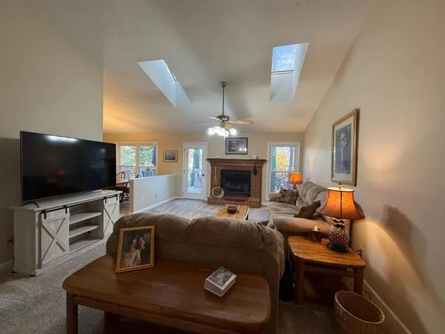 a living room with furniture a fireplace and a flat screen tv