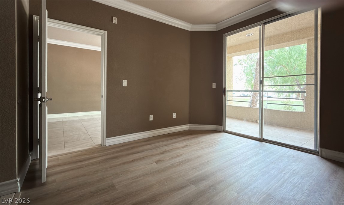 210 East Flamingo Road, Unit 112 Las Vegas, NV 89169 - Photo 13 of 59 Crown molding and wood flooring complement sliding glass doors that open to a private patio.