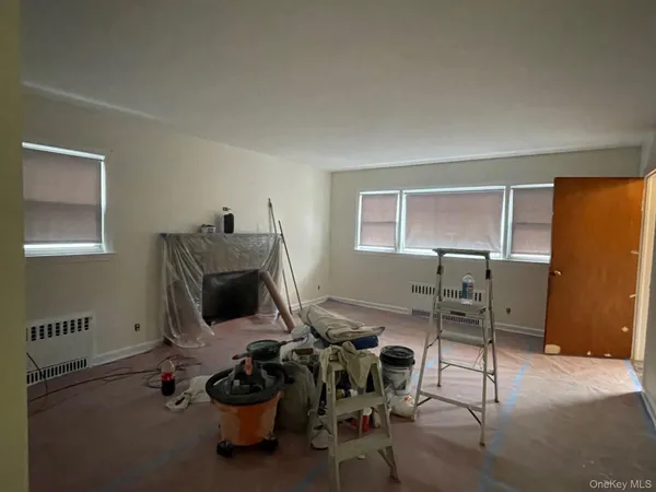 a living room with furniture a flat screen tv and a window