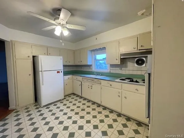 a kitchen with a refrigerator sink and cabinets