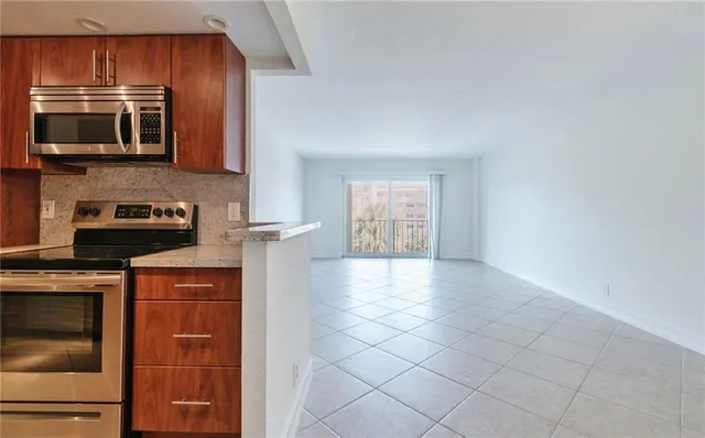 a kitchen with stainless steel appliances granite countertop a refrigerator stove and sink