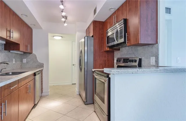 a bathroom with a granite countertop sink a toilet and shower