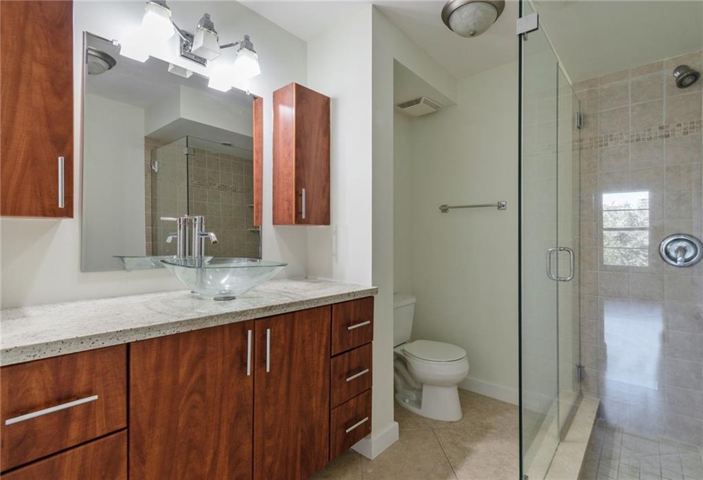 950 Ponce De Leon Road, Unit 408 Boca Raton, FL 33432 - Photo 10 of 50 a bathroom with a granite countertop sink a toilet and shower