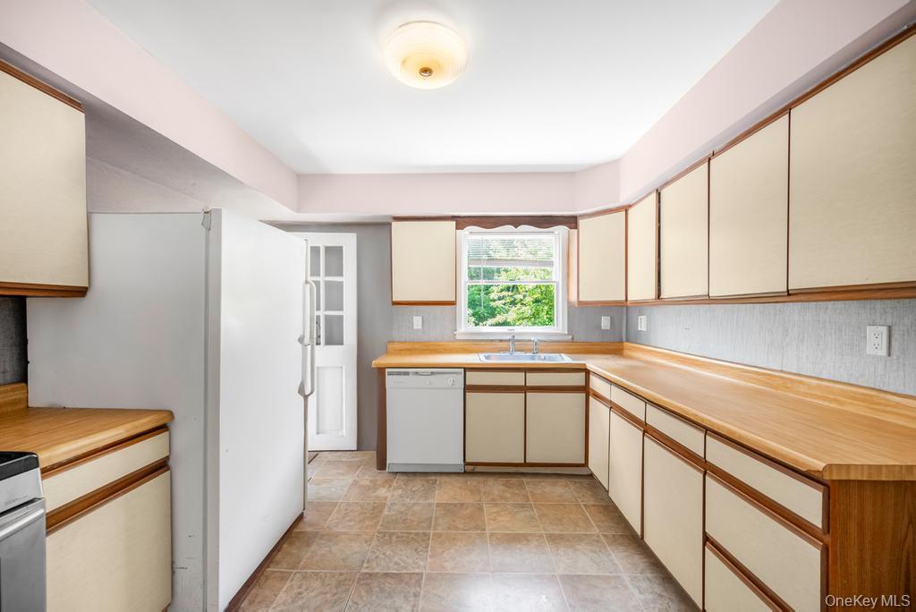 4 Cooks Lane Westhampton, NY 11977 - Photo 21 of 33 Kitchen featuring white dishwasher, cream cabinetry, light countertops, and stone finish flooring