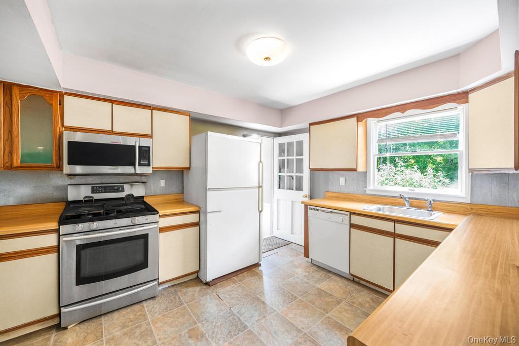 4 Cooks Lane Westhampton, NY 11977 - Photo 24 of 33 Kitchen featuring appliances with stainless steel finishes, tasteful backsplash, and wooden counters