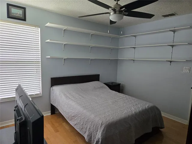 a bedroom with a bed and a ceiling fan