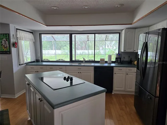 a kitchen with a sink a stove a refrigerator a sink and a window