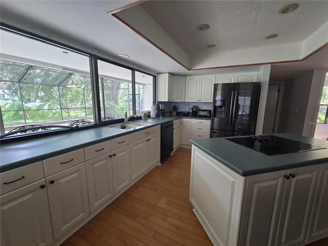 a kitchen with stainless steel appliances granite countertop a sink a stove and a refrigerator