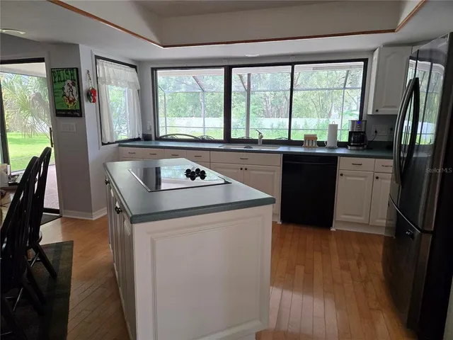 a kitchen with granite countertop a sink a stove and refrigerator