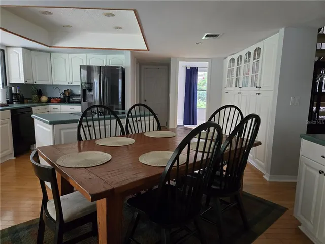 a view of a a dining room with furniture window and wooden floor