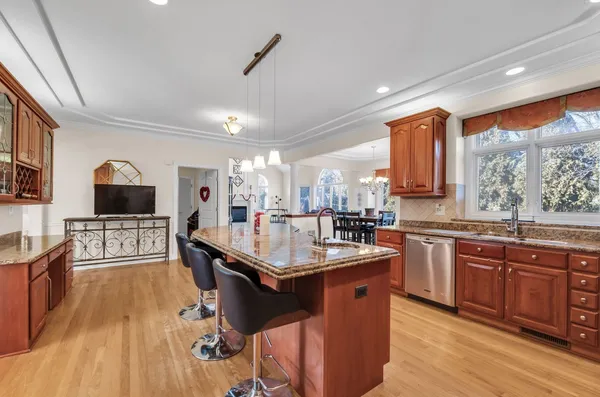 a kitchen with stainless steel appliances granite countertop a sink a stove and a wooden floors