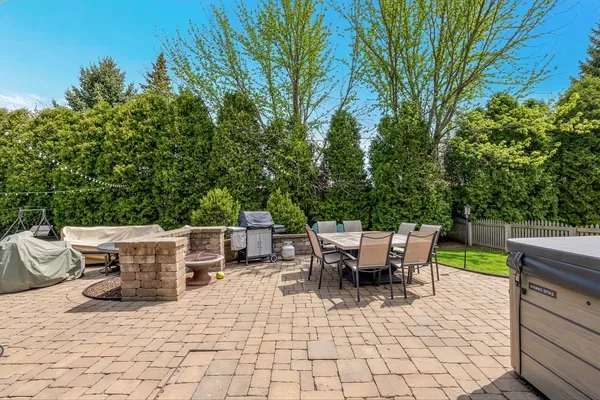 a view of a patio with a dining table and chairs with wooden fence and plants