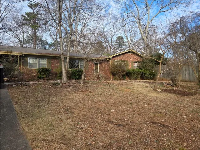 a view of a house with a yard and large tree