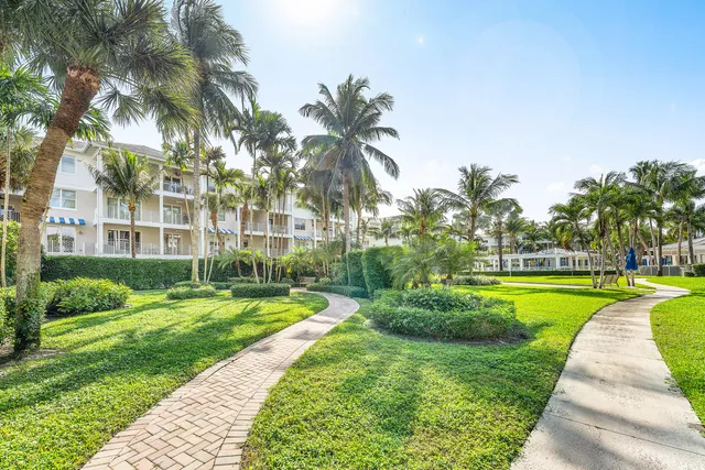 a view of a building with a big yard and palm trees