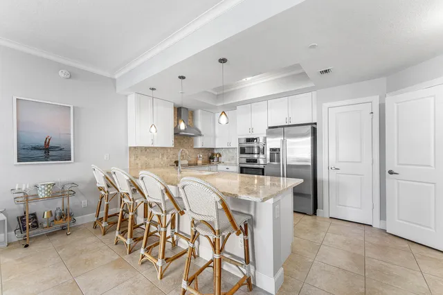 a kitchen with stainless steel appliances a table and chairs in it