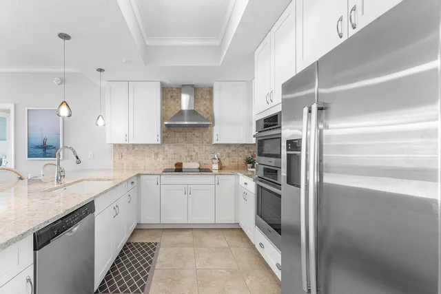 a kitchen with stainless steel appliances granite countertop a refrigerator and a sink