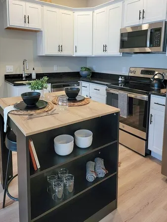 a kitchen with stainless steel appliances granite countertop a stove a microwave and wooden cabinets