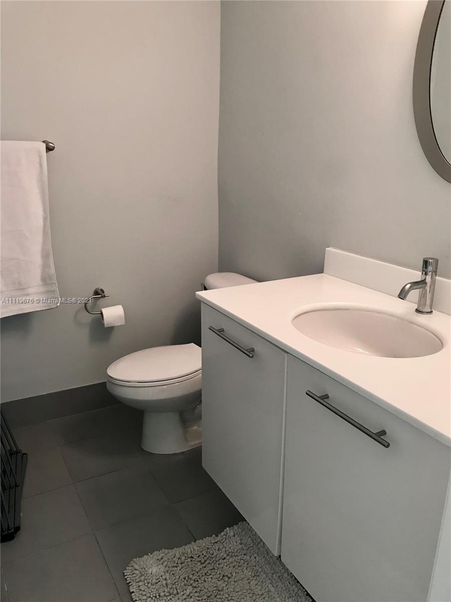 92 Southwest 3rd Street, Unit 1503 Miami, FL 33130 - Photo 12 of 14 a bathroom with a sink a toilet and a mirror