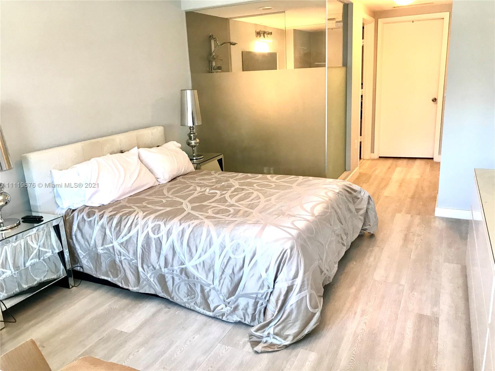 92 Southwest 3rd Street, Unit 1503 Miami, FL 33130 - Photo 5 of 14 a bedroom with a bed and a night stand