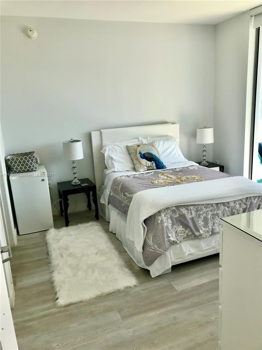 92 Southwest 3rd Street, Unit 1503 Miami, FL 33130 - Photo 8 of 14 a bedroom with a bed and wooden floor