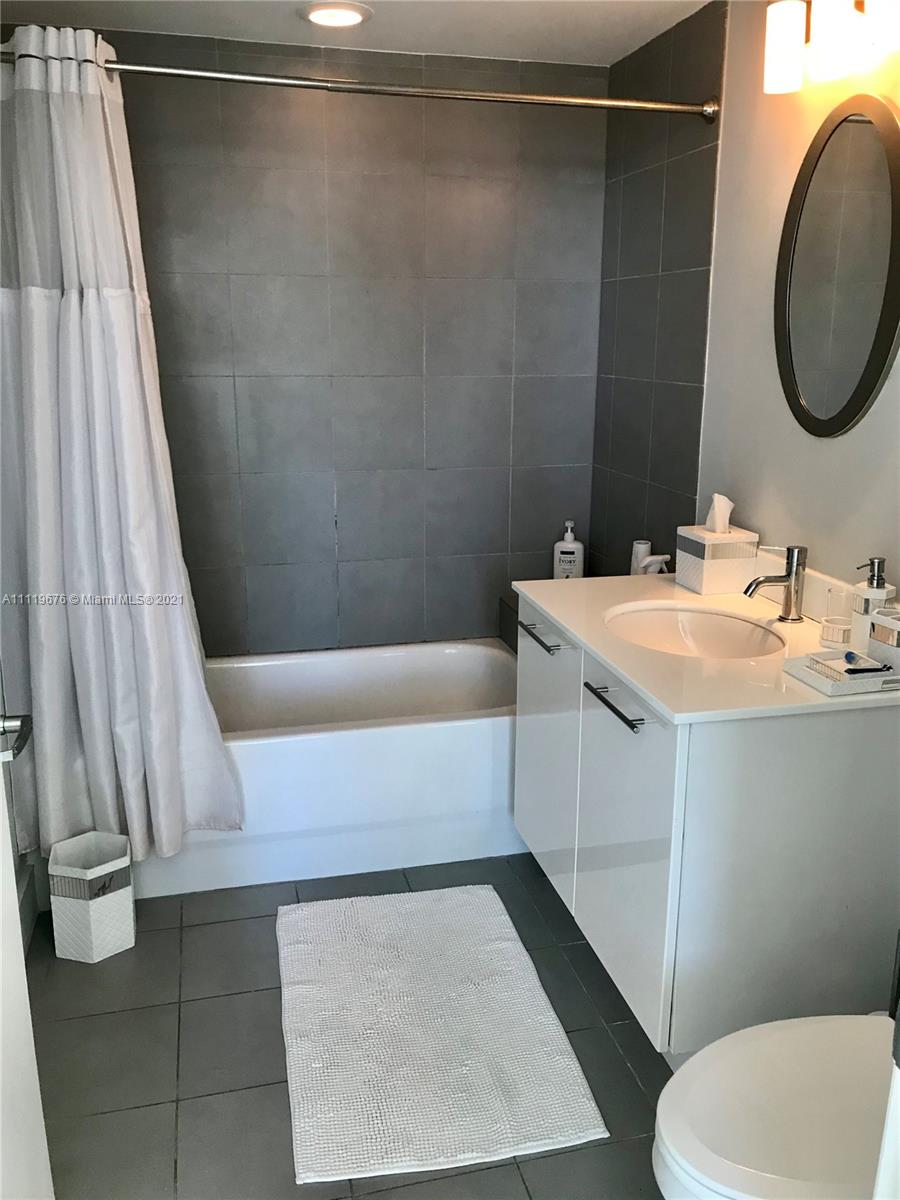 92 Southwest 3rd Street, Unit 1503 Miami, FL 33130 - Photo 10 of 14 a bathroom with a sink and a mirror