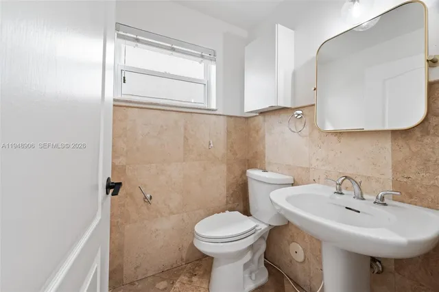 a bathroom with a sink a toilet and mirror