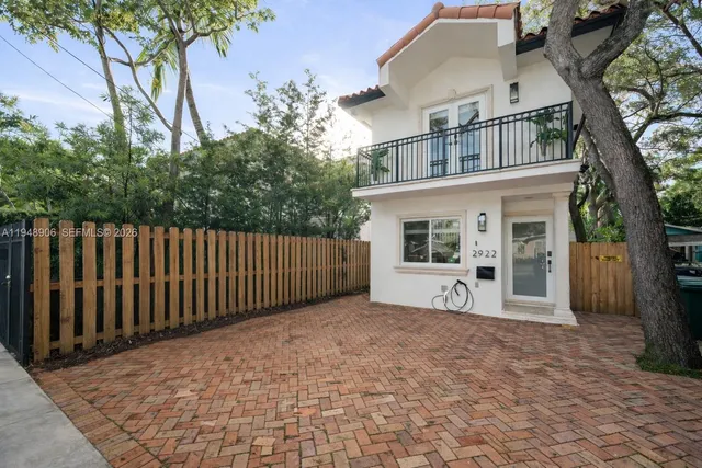 a view of house with large windows and a small yard