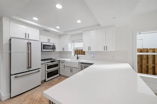 a kitchen with stainless steel appliances a refrigerator stove microwave and sink