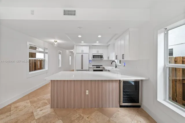 a kitchen with kitchen island sink stove and refrigerator