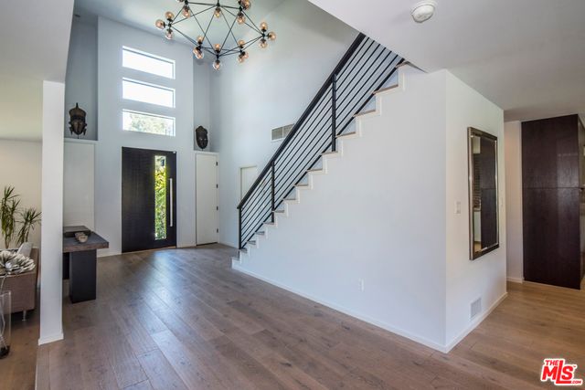 a view of a hallway with wooden floor and stairs