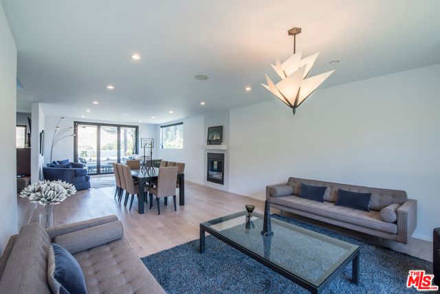 a living room with furniture dining table and a chandelier